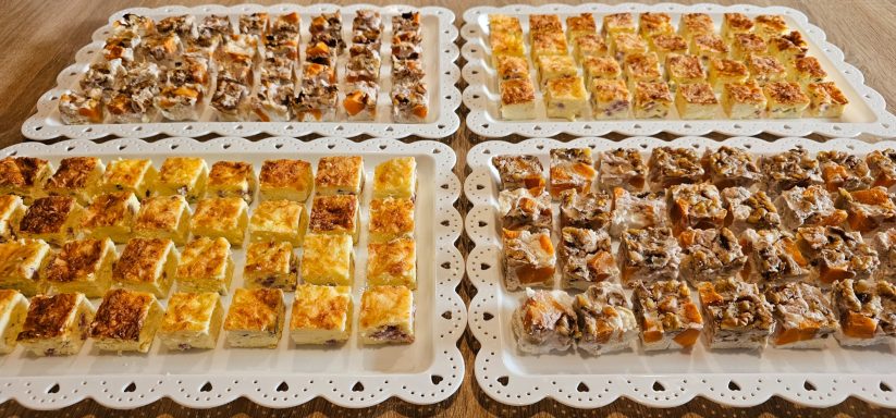 Assortiment de pâtisseries colorées disposées sur des plateaux.